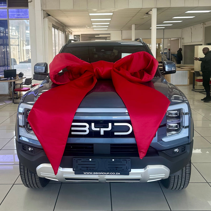 BYD vehicle with an extra large red bow in a showroom