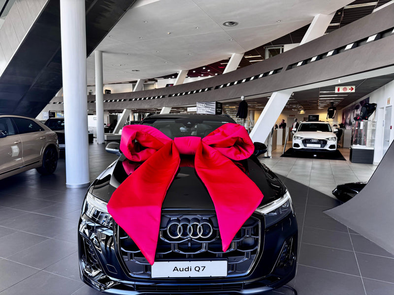 Audi Q7 with a extra large red bow in a showroom