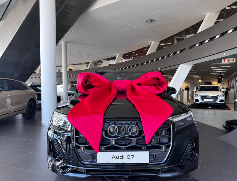 Audi Q7 with an extra large red bow in a showroom setting